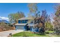 Charming two-story home with a well-maintained lawn, mature trees, and an attached two car garage at 1067 W Alder St, Louisville, CO 80027