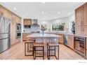 Bright and open kitchen features light wood cabinets, a large island with seating, and stainless steel appliances at 1067 W Alder St, Louisville, CO 80027