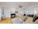 Open concept living room with a cozy fireplace and hardwood floors at 10950 Elk Horn Run, Littleton, CO 80125