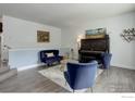 Cozy living room featuring hardwood floors, modern furnishings, and a decorative piano at 112 Dawson Pl, Longmont, CO 80504