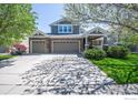 Charming two-story home featuring a three-car garage and well-maintained front yard with mature trees at 14246 Piney River Rd, Broomfield, CO 80023