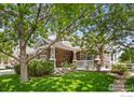 Attractive home showcasing stone accents, a welcoming front porch, and beautifully landscaped yard with green lawn at 14246 Piney River Rd, Broomfield, CO 80023