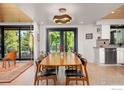 Dining room with wood table, modern chairs, and outdoor views through sliding glass doors at 1579 W Costilla Pl, Littleton, CO 80120