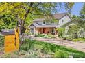 Landscaped home exterior features a well-manicured lawn, mature trees, and a charming front entrance at 1579 W Costilla Pl, Littleton, CO 80120