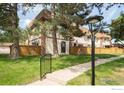 Beautiful townhome exterior with well manicured lawn, quaint front fence and mature trees at 1901 W 101St Ave, Thornton, CO 80260