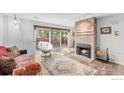Cozy living room with brick fireplace, modern light fixtures, and sliding glass doors to the patio at 1901 W 101St Ave, Thornton, CO 80260