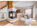 Inviting living room with a cozy fireplace, open to the dining area and featuring hardwood floors at 20764 E 47Th Ave, Denver, CO 80249