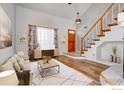 Open-concept living room with a staircase, hardwood floors, and large windows at 20764 E 47Th Ave, Denver, CO 80249
