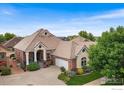 An aerial view of a well-maintained property with lush landscaping and a charming brick house at 2324 Steppe Dr, Longmont, CO 80504