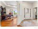 Bright and inviting foyer with tile flooring and a view into the hardwood-floored office at 2324 Steppe Dr, Longmont, CO 80504
