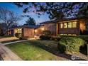 Well-manicured lawn and landscaping complement this brick home with an attached two-car garage and inviting entryway at 2777 S Elmira St # 17, Denver, CO 80231