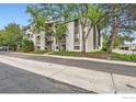 Condo building featuring private balconies, mature trees, and well-maintained landscaping at 3515 28Th St # 108, Boulder, CO 80301