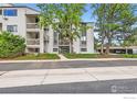Condo building featuring private balconies, mature trees, and well-maintained landscaping at 3515 28Th St # 108, Boulder, CO 80301