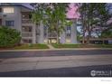 Condo building featuring private balconies, mature trees, and well-maintained landscaping at 3515 28Th St # 108, Boulder, CO 80301