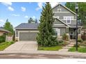 Inviting home showcasing a well-maintained lawn, mature trees, a spacious driveway, and an attached two-car garage at 4219 Frederick Cir, Longmont, CO 80503