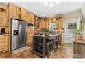 Bright kitchen featuring wooden cabinets, stainless appliances, and a central island with seating at 6125 Mallow Grn, Frederick, CO 80530