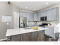 Stylish kitchen with stainless steel appliances, a large island, and ample cabinet space offers modern functionality at 675 Lene Ln, Berthoud, CO 80513