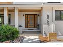 Inviting front entrance with a modern wood door, white brick accents, and well-maintained landscaping at 6969 Harvest Rd, Boulder, CO 80301
