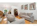 Bright living room features hardwood floors, neutral sofas, and vaulted ceilings at 7796 Xavier Ct, Westminster, CO 80030