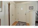 Bright entryway with wood floors, coat closet, and front door with decorative window at 915 19Th Ave, Longmont, CO 80501