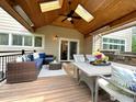A spacious deck with outdoor seating, including a wicker sofa, dining table, and built-in barbecue area at 1069 Monarch Way, Superior, CO 80027
