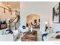Bright living room featuring staircase, white furniture, and stylish decor at 1069 Monarch Way, Superior, CO 80027