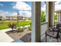 Inviting front porch with seating, overlooking a green lawn in a residential neighborhood at 1125 Anker Dr, Erie, CO 80516