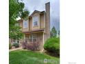 A charming two-story home with a brick chimney, inviting front porch, and well-maintained landscaping at 118 Pheasant Run, Louisville, CO 80027