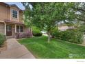Well-manicured front yard showcasing a lush green lawn, mature tree, and inviting walkway to the home at 118 Pheasant Run, Louisville, CO 80027