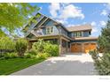 Beautiful two-story blue home with a well-manicured lawn, a two-car garage, and gorgeous landscaping at 1279 Greening Ave, Erie, CO 80516