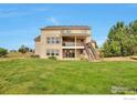 Beautiful backyard featuring a two-level patio and lush green lawn, perfect for outdoor entertaining at 14825 Almstead St, Hudson, CO 80642