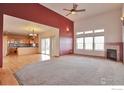 Open-concept living room features a fireplace, large windows, and seamless flow into the kitchen at 14825 Almstead St, Hudson, CO 80642