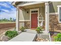 Inviting front porch with decorative accents and a cozy swing, perfect for enjoying quiet moments at 16818 E 119Th Ave # A, Commerce City, CO 80022
