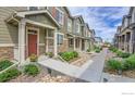 Charming townhome exteriors featuring landscaped walkways and inviting front porches in a modern community at 16818 E 119Th Ave # A, Commerce City, CO 80022