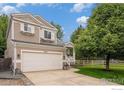 Charming two-story home features a two-car garage, well-maintained lawn, and inviting front porch at 1820 Gordon Dr, Erie, CO 80516