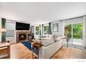 Inviting living room with a cozy fireplace, large windows, and sliding glass door at 1820 Gordon Dr, Erie, CO 80516