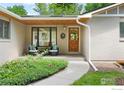 Covered front porch featuring a seating area and a decorative wooden front door at 1860 Hawthorn Ave, Boulder, CO 80304