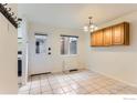 Bright dining room with white tile floor, rear entrance, and chandelier light fixture at 3161 Madison Ave # 108, Boulder, CO 80303