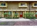 Charming townhome exterior with a welcoming red door, lush landscaping, and inviting curb appeal at 3363 Madison Ave # 121, Boulder, CO 80303