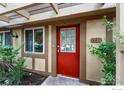 Close-up of the townhome's entrance with a vibrant red door, decorative trim, and well-maintained greenery at 3363 Madison Ave # 121, Boulder, CO 80303