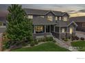 Charming two-story home featuring a covered front porch with chairs and manicured landscaping at 3891 W 149Th Ave, Broomfield, CO 80023