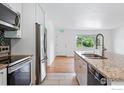 Modern kitchen featuring stainless steel appliances, granite counters, and white cabinets at 4462 Hamilton Ct, Boulder, CO 80305