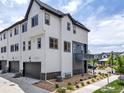 Exterior side view of townhome featuring a two-car garage, private balcony, and modern architecture at 605 Promenade Dr, Superior, CO 80027