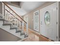 Bright entryway features hardwood floors, a decorative front door and staircase at 7409 Mount Meeker Rd, Longmont, CO 80503
