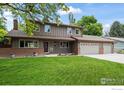 Charming two-story home featuring a manicured lawn and a three-car garage at 7409 Mount Meeker Rd, Longmont, CO 80503