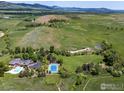 Expansive aerial view of estate featuring tennis court, pool, and meticulously manicured grounds at 8000 N 41St St, Longmont, CO 80503
