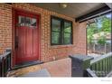 Inviting covered front porch with red brick and dark trim at 1010 Euclid Ave, Boulder, CO 80302