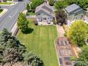 Expansive backyard with lush lawn, garden beds, and patio seating area at 10400 Foxfire St, Firestone, CO 80504