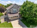 Charming two-story home featuring a well-maintained front yard and mature tree at 10400 Foxfire St, Firestone, CO 80504