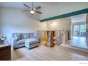 Cozy living room with vaulted ceilings, a ceiling fan and stylish wood floors and staircase access at 10940 Utica Ct, Westminster, CO 80031